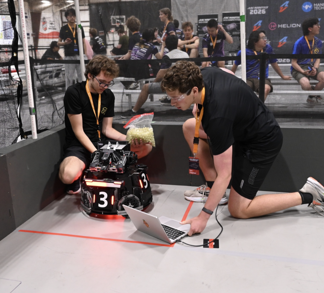 CU Robotics members working on a competition robot in the arena